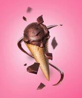 Composition levitation of chocolate ice cream waffle cone with pieces of chocolate on pink background. In the air, vertical photo