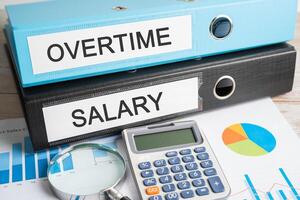 Overtime, Salary. Binder data finance report business with graph analysis in office. photo