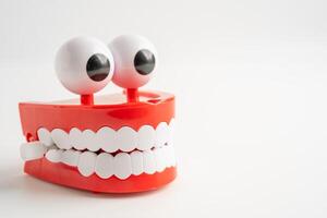 Tooth funny toy denture red color jaw and eye on whtie backgroud with copy space. photo