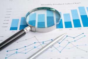 Magnifying glass on spreadsheet and graph paper. Financial development, Banking Account, Statistic, Investment Analytic research data economy, Business. photo