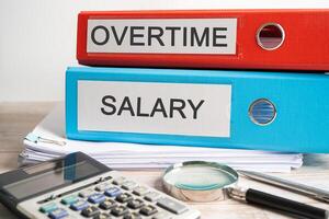 Overtime, Salary. Binder data finance report business with graph analysis in office. photo