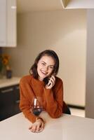 Charming Young Woman Talking on Mobile Phone at Home photo