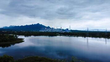 Landscape of the Mae Moh coal-fired power plant in Lampang, Thailand, with a view of the reservoir and a sky with clouds. photo