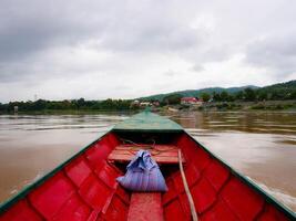 View on a local passenger boat sailing on the Mekong River with views of nature and Lao villages. photo