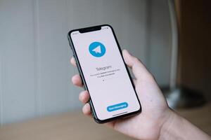 CHIANG MAI, THAILAND, JUN 22, 2020 . Woman hand holding iPhone X with social networking service Telegram on the screen. iPhone 10 was created and developed by the Apple inc photo