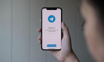 CHIANG MAI, THAILAND, JUN 22, 2020 . Woman hand holding iPhone X with social networking service Telegram on the screen. iPhone 10 was created and developed by the Apple inc. photo