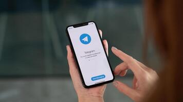 CHIANG MAI, THAILAND, OCT 3, 2021 . Woman hand holding iPhone X with social networking service Telegram on the screen. iPhone 10 was created and developed by the Apple inc photo