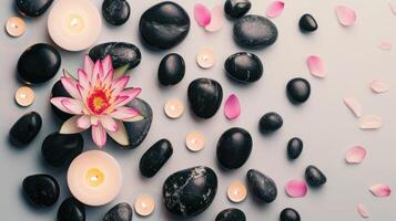 Light background with lotus, black stones and candles. View from above photo