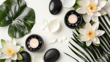 Light background with lotus, black stones, candles and tropical leaves. View from above photo