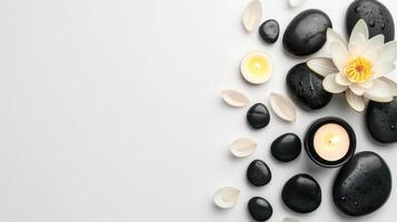 White background with lotus flower,black stones and candles with copy space. Top view photo