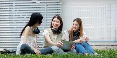 College student having discussion under tree on campus, preparing for exam, learning and reading books together photo