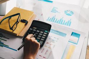 Close up Accountant using calculator for calculating financial expense photo