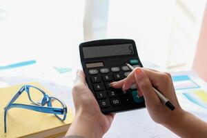Close up Accountant using calculator for calculating financial expense photo