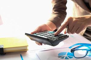 Close up Accountant using calculator for calculating financial expense photo
