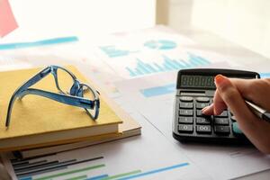 Close up Accountant using calculator for calculating financial expense at home office photo