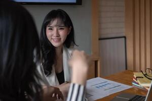 Two diverse businesswomen discussing business project working together in office photo