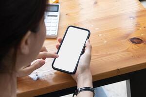 Young girl hands holding mobile phone touching finger mockup white blank display, empty screen for social media app ad at home. Mobile application tech concept photo
