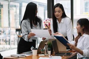 Business asian team discussing working analyzing with financial data and marketing growth report graph in team, presentation and brainstorming to strategy planning making profit of company photo