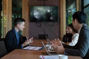A group of business people are meeting to analyze data for marketing plan at meeting room photo