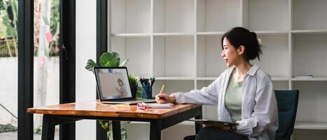 Cropped photo of woman writing making list taking notes in notepad working or learning on laptop indoors- educational course or training, seminar, education online concept