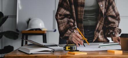 Cropped woman architect design working drawing sketch plans blueprints and making architectural construction model in architect studio. photo