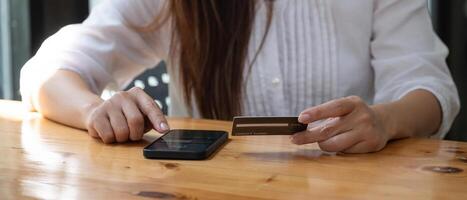 Hands holding credit card and using mobile phone. Online shopping. photo