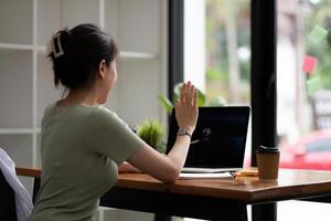 Cropped view of woman waving hand while having call with laptop computer photo