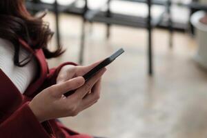 Close up women's hands use a smartphone for online shopping, social networking, or remote work photo