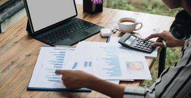 Close-up calculator to calculate the company's financial results On the wooden table in the office and business work background, tax, accounting, statistics, and analytical research concept photo