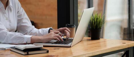 Close up of female hands while typing on laptop computer photo