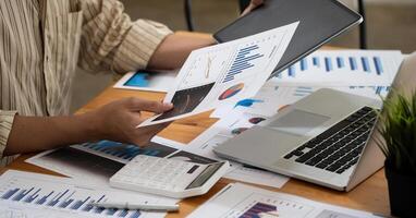 Close up hand of accountant working with computer and calculator for business and financial expense photo