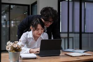 University asian students learning language using digital tablet and internet, working project together. Exam preparation. Online education concept. team of coworkers brainstorming. Meeting. Teamwork photo