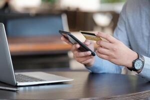 Online payment, Close up man's hands holding smartphone and using credit card for online shopping photo