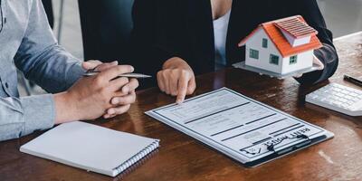 Real estate agent talked about the terms of the home purchase agreement, customer sign the documents to make the contract legally, Home sales and home insurance concept photo
