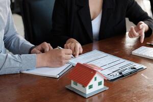 Real estate agent talked about the terms of the home purchase agreement, customer sign the documents to make the contract legally, Home sales and home insurance concept photo
