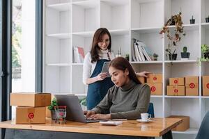 Two asian woman working together for SME project. Young Owner people startup for Business Online, SME, Delivery Project. Online Business Concept photo