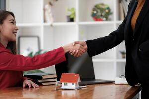 Estate agent and customer shaking hands after finished contract after about home insurance and investment loan photo