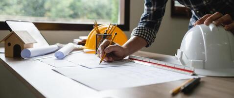 Engineer architect designer freelance work on start-up project drawing, construction plan. architect design working drawing sketch plans blueprints and making construction model. Architects concept. photo