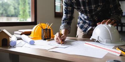 Engineer architect designer freelance work on start-up project drawing, construction plan. architect design working drawing sketch plans blueprints and making construction model. Architects concept. photo