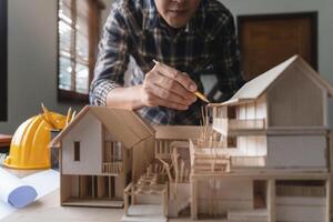 Engineer architect designer freelance work on start-up project with home model, construction plan. architect design working drawing sketch plans blueprints and making construction model. Architects photo