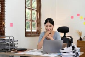 Portrait accounting asian woman working for financial with paperwork using laptop computer. photo