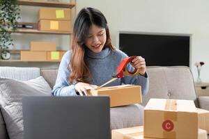 Startup small business, Young woman working freelance and packing box delivery products to customers, Ordered online photo