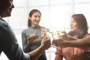 Group of happy colleagues having fun at a new year celebration or business success. Coworkers with diverse people at the office party photo