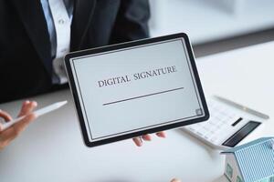 Close-up of female hand signing e-document with on tablet. Electronic signature and modern technologies concept photo