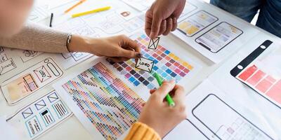 creative digital development agency brainstorming about mobile app interface wireframe design on desk at modern office photo