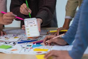 creative digital development agency brainstorming about mobile app interface wireframe design on desk at modern office photo