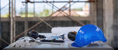 Engineer tool architecture blueprint design and safety helmet hardhat on meeting table with contractors paper project with engineer and architect working and discussing in background photo