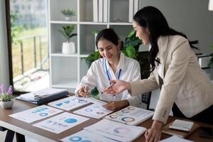 Businesswomen discussing charts and graphs in office. Concept of teamwork and data analysis photo