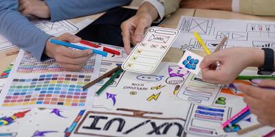 Creative UX Developer and UI Designer Brainstorming Session with Color Palettes, Wireframes, and Sketches for Innovative Digital Solutions photo