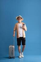 Portrait of Asian man posing on blue background, traveling in summer photo